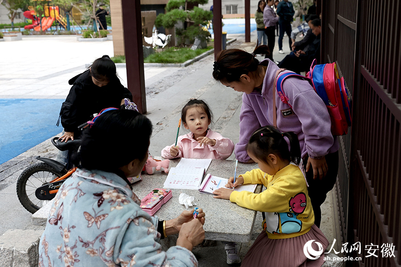 放學(xué)后，孩子們聚在廣場(chǎng)長(zhǎng)廊寫作業(yè)。人民網(wǎng)記者 張俊攝