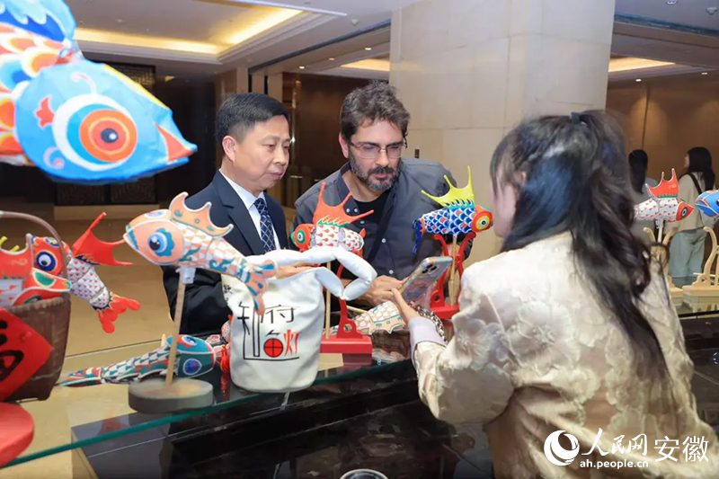 巴西旅行商米內(nèi)維諾·奧爾蒂斯·內(nèi)托·西爾維里奧（中）對(duì)魚燈充滿好奇。人民網(wǎng)記者 王曉飛攝